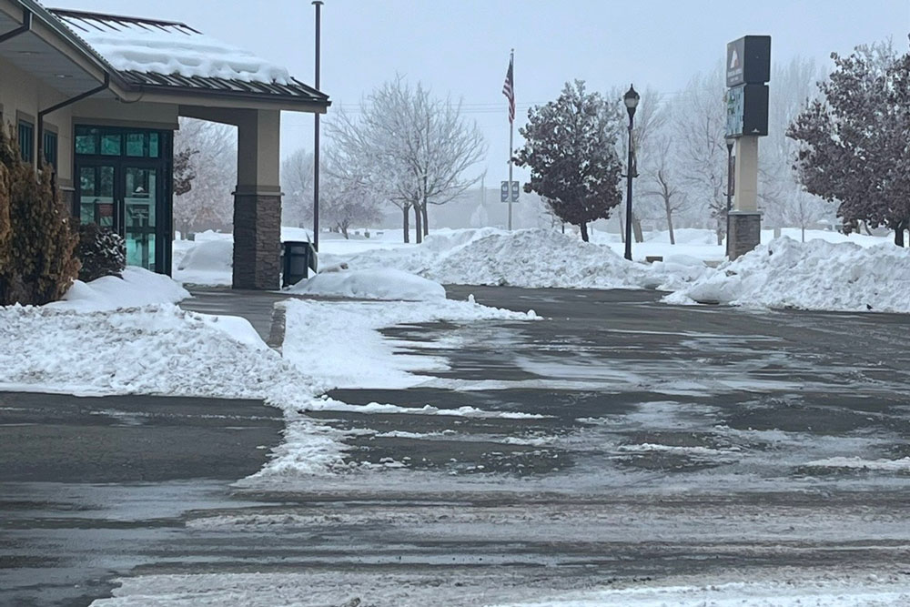 asphalt parking lot with snow piled on the sides